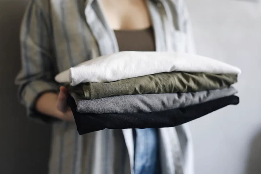 Folded corporate uniform shirts held in a stack